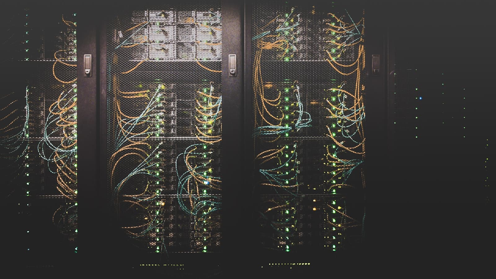 Server rack with glowing network cables in a dark data center